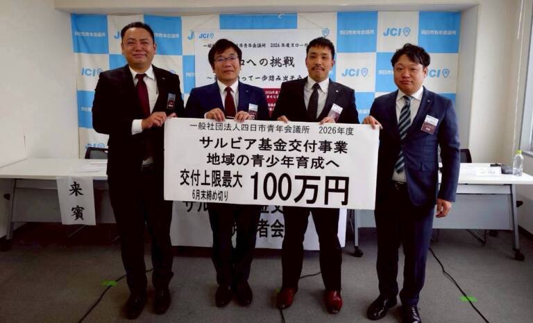 「サルビア基金交付事業 地域の青少年育成へ 交付上限最大100万円」と書かれたボードを掲げる、一般社団法人四日市青年会議所のメンバー4名