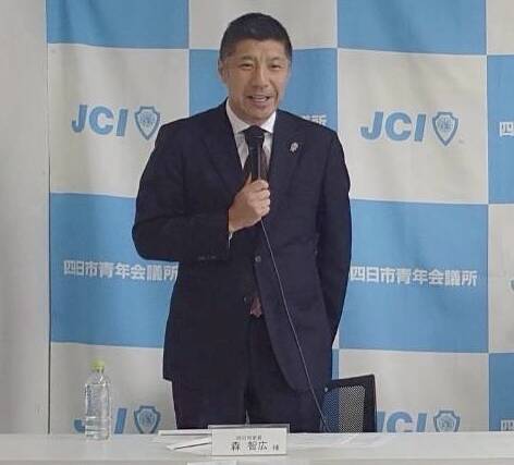 四日市青年会議所の記者会見にて、マイクを持ち来賓挨拶をする森智広・四日市市長