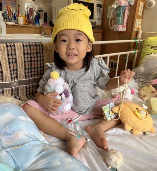 入院中のベッドの上でおもちゃを持つ笑舞ちゃん