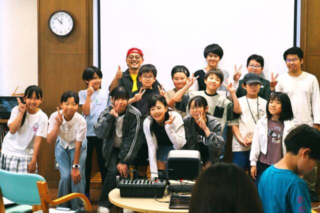 完成特別試写会を終え、笑顔で記念撮影する子どもたちと小林渚監督