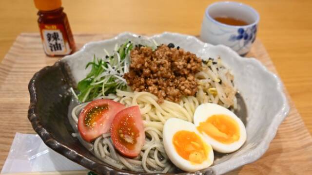 肉みそとゆで卵、トマトと水菜が盛り付けられた四日市まぜ麵