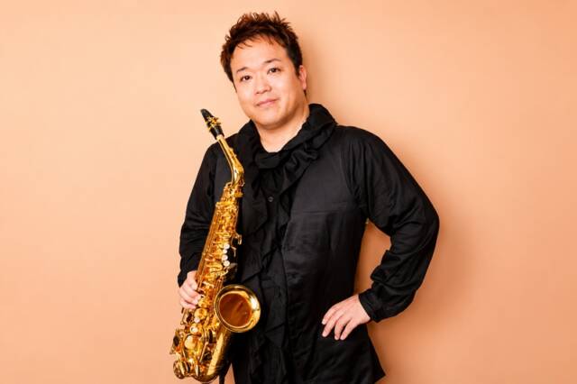 サクソフォンを手にポーズを取るサクソフォン奏者の大森義基さん
