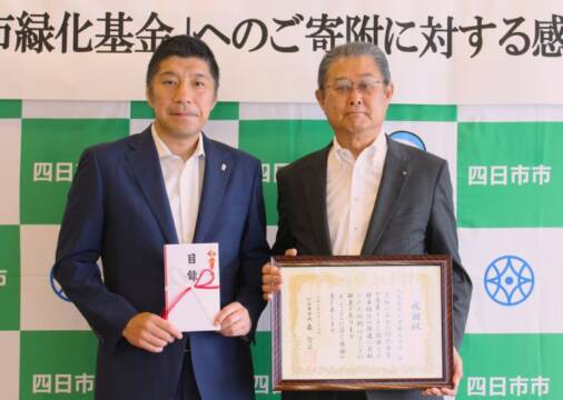 画面右の九鬼十三男社長が画面左の森智広市長に寄付目録を贈呈した