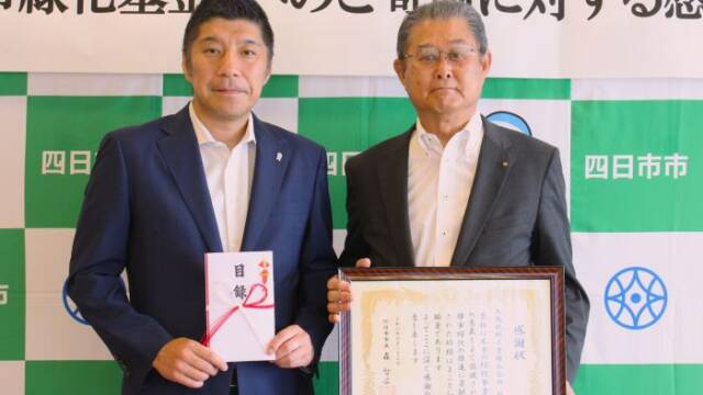 画面右の九鬼十三男社長が画面左の森智広市長に寄付目録を贈呈した