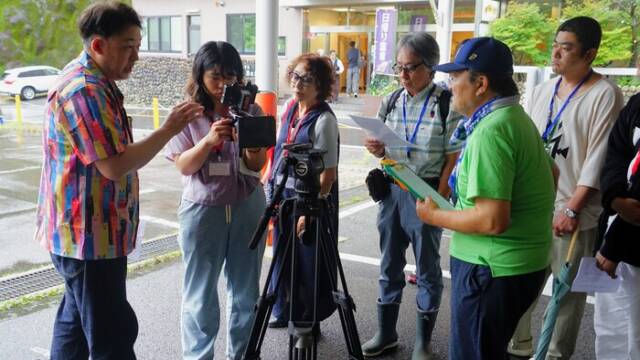 映画塾の撮影講習で、カメラを三脚に取り付ける参加者。