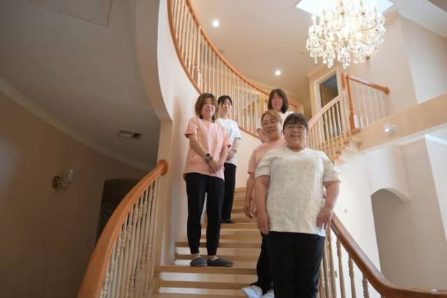 らせん階段に並ぶ５人のスタッフ