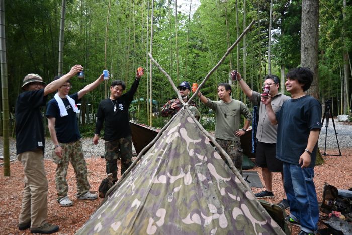 軍幕キャンプ愛好家の人たち7人でテントを囲み乾杯している