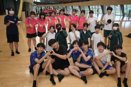 西日野卓球クラブのメンバーと一緒に写真を撮る笹川中学校の卓球部員