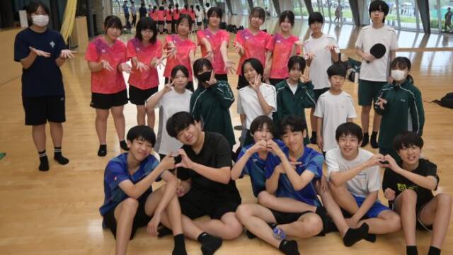 西日野卓球クラブのメンバーと一緒に写真を撮る笹川中学校の卓球部員