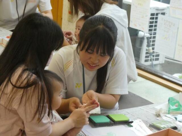 赤ちゃんの手に触れる生徒