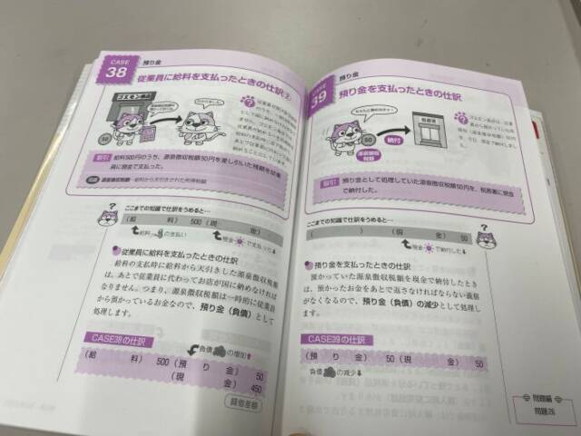猫のイラストが描かれた日商簿記検定初級のテキスト