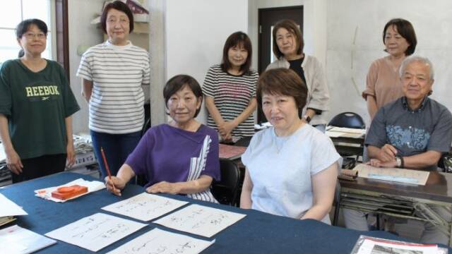 書道教室の位田弥生さん（前列右）。隣にすわる恩師の荒木敬子さんや教室の仲間と