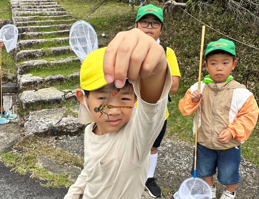 捕らえたトンボを見せてくれる子ども