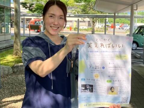 講演会「とにかく笑えればいい」のポスターを持つ人
