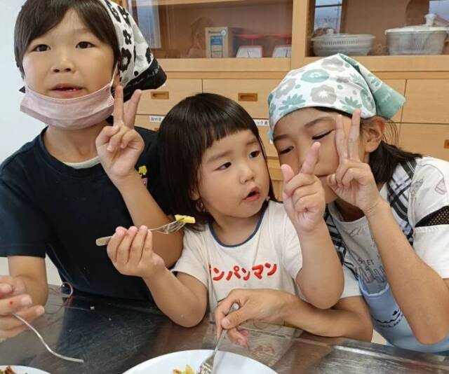 夏ミカンゼリーを手にしてⅤサインをする子ども3人