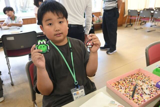 アイロンビーズで作った作品を手にする子ども
