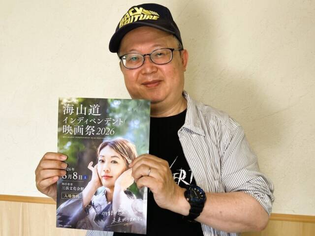 映画祭のチラシを手に持ち、来場を呼び掛ける市川さん