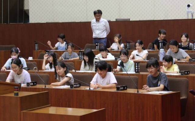 本会議場で電子採決システムを体験する子どもたち