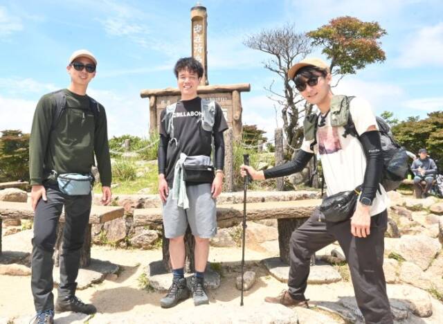 山頂に着いた登山客の3人の男性
