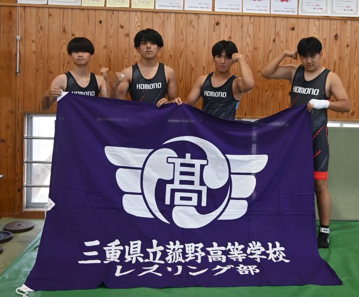 学校名と校章の入った旗を持ってガッツポーズをとる部員