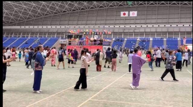 中央のやぐらを囲むように、来場者たちが輪になって盆踊りをしている