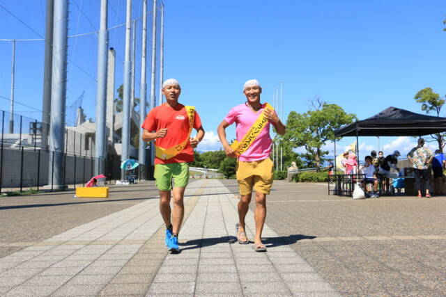 四日市ドームの周回コースを2人の参加者が並走している