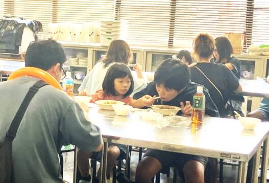 四日市市の大矢知地区市民センター内で、来場者が「ちょこっと食堂」で食事を楽しんでいる様子。