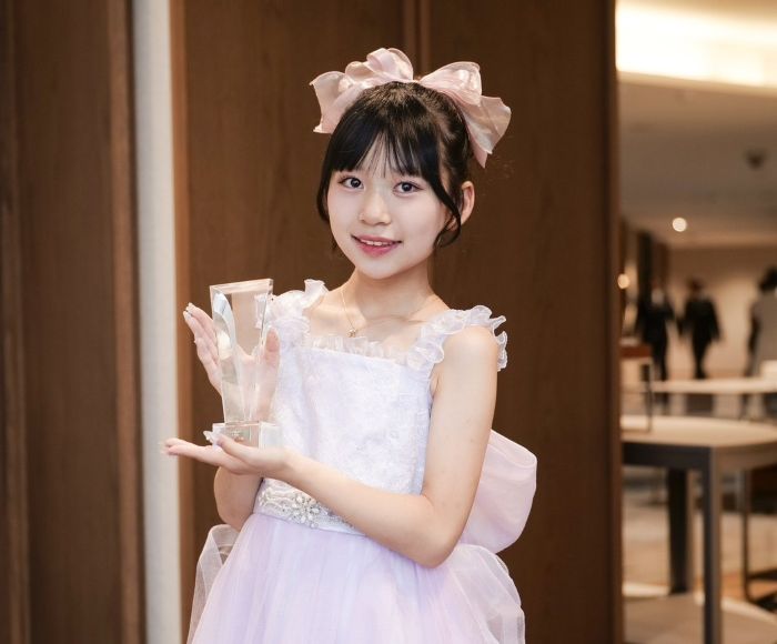 ドレスを着てトロフィーを手にするゆさんさん