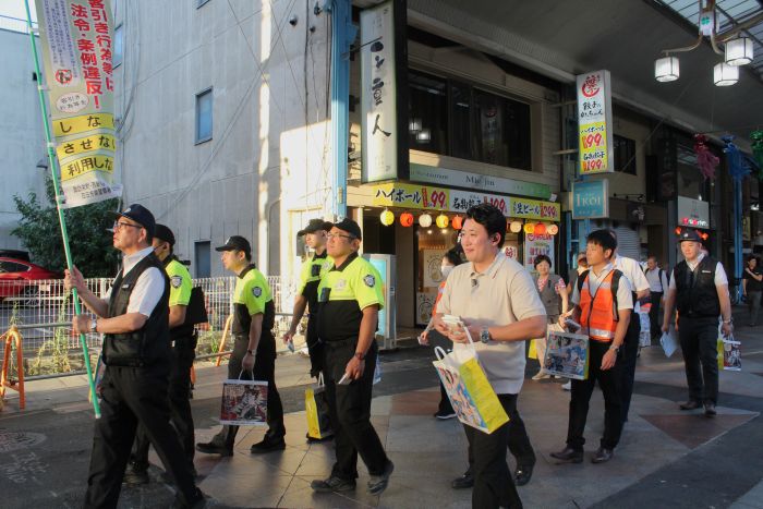 商店街を協力を訴えながら行進する参加者たち