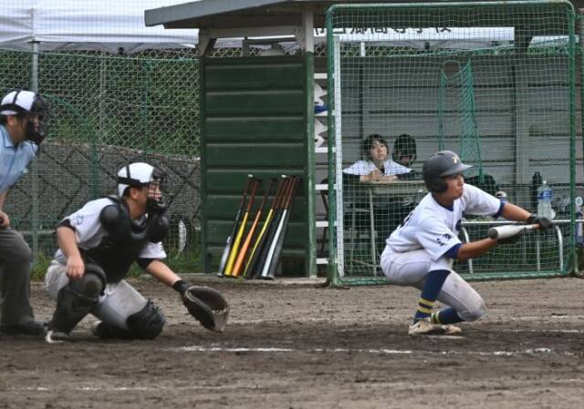 バンドを狙う石本選手キャッチャーと審判がその後ろに並ぶ