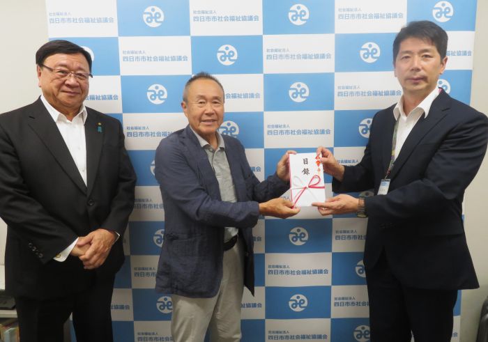 西村敦志常務理事(右)に寄付目録を手渡す金森武志副理事長と笹岡秀太郎副会長