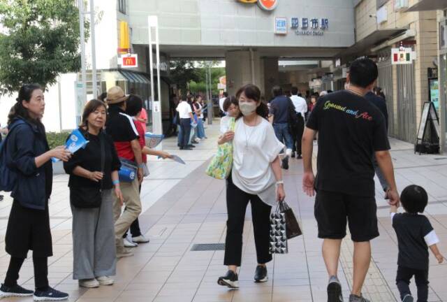 買い物客らにチラシを配る参加者たち