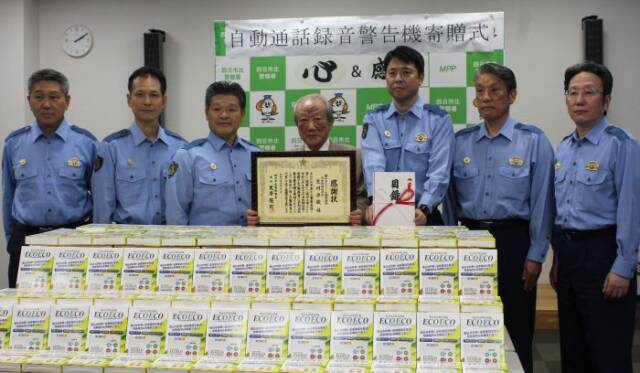 録音警告機と6署長と記念撮影をする生川平藏さん(中央)