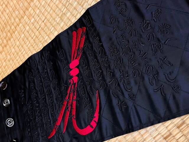 南楠鯨船保存会オリジナルのマークをあしらい、「鯨船の唄」の歌詞を黒糸で刺繍したオーダー品の帯