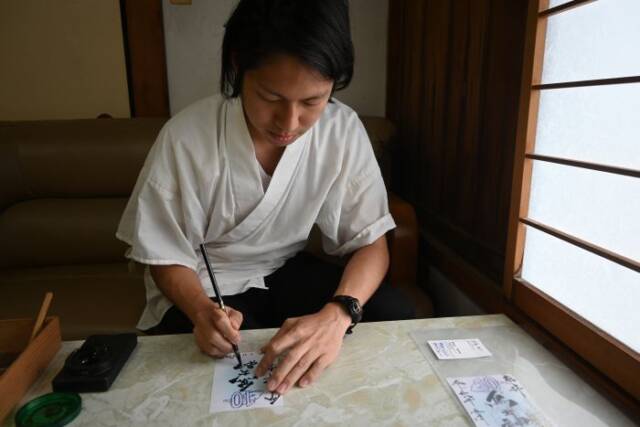 御朱印に神社名を書く喜多嶋さん