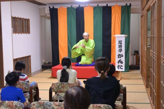 高座で落語を披露する落語家