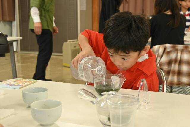 ペットボトルに入った冷水でお茶を淹れる子ども