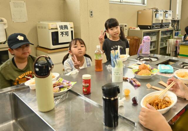 子ども食堂で食事を楽しむ3人の子ども