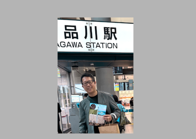 東京でイベントのチラシ配りをした際、品川駅でチラシを手に写る田中さん