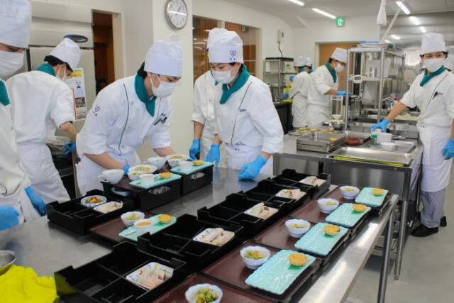 厨房で料理作りを進める学生たち