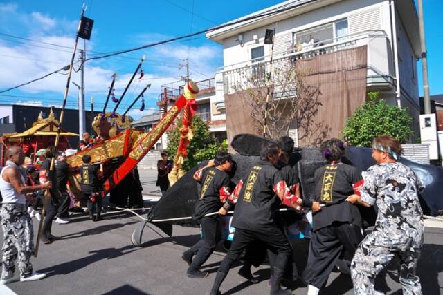 磯津鯨船「大正丸」で、船上の踊り子と鯨役が激しく向き合い、攻防を繰り広げている