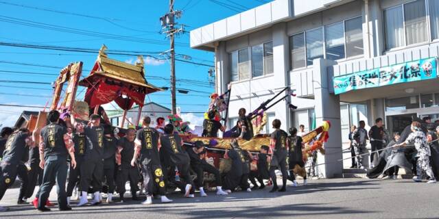 秋晴れの屋外で、磯津鯨船「大正丸」が船体を大きく傾けながら練りを披露している