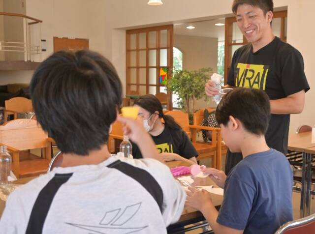 ペットボトルロケットを作る子どもたちと教える中島さん