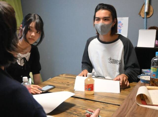 フリースクールの代表にイベントの説明をする中川さん(右)と金城さん