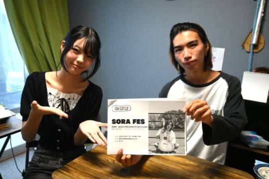 ポスターを手にする中川さんと金城さん
