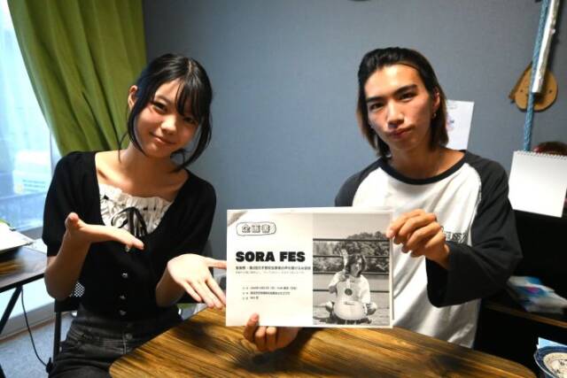 ポスターを手にする中川さんと金城さん