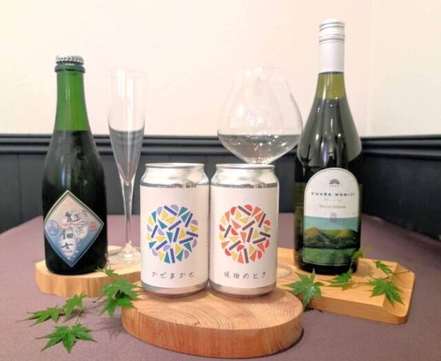 イベントで提供される四日市の地元のお酒。左端に伊藤酒造の日本酒、中央にいきかたブルワリーのクラフトビール2本、右側に水沢ワインのボトルが並んでいる